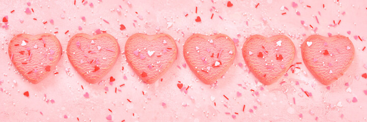 Valentine day decorated heart shaped cookies on pink background, top view