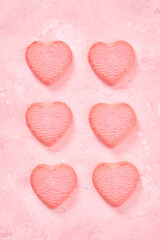 Valentine day decorated heart shaped cookies on pink background, top view
