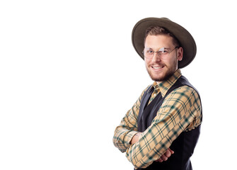 Young european man in eyewear, trendy cowboy hat and shirt with hands crossed on chest looking to camera and smiling