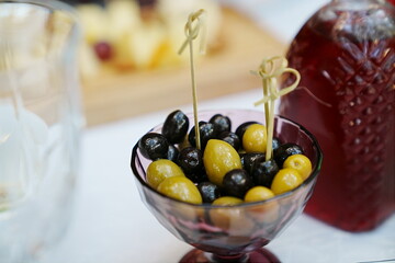 a bowl of green and black olives on the dining room table. 