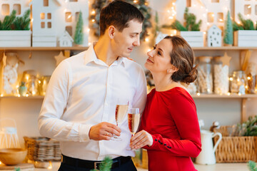 a happy and elegant couple with champagne in the Christmas kitchen. 