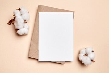 Holiday greeting card mockup with dried cotton flowers on beige background, top view, flat lay