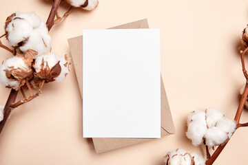 Holiday greeting card mockup with dried branch of cotton flowers and envelop on beige background,...