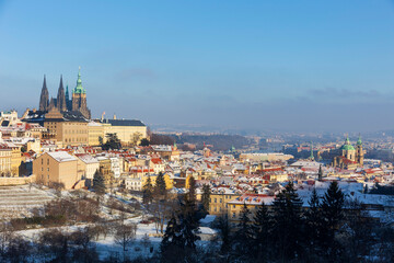 Obraz premium Snowy Prague City with gothic Castle from Hill Petrin in the sunny Day, Czech republic