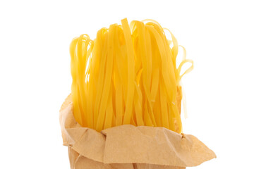 Homemade raw noodles in a kraft paper bag, macro, isolated on white background.