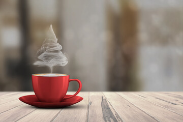 Christmas tree shape of steaming coffee cup on white wooden floor against bokeh background. Copy Space.