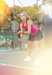 Woman tennis player training on court. Woman using racket to hit ball.