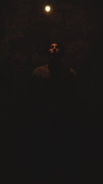 Tired and sad man tied on chair in dark basement. Scary and old place in underground. Silhouette black