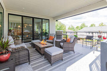 A luxurious spacious deck with stylish patio furniture and a table fire-pit heater - obrazy, fototapety, plakaty