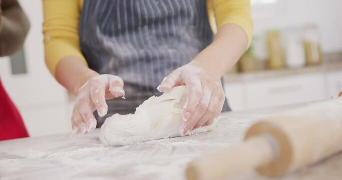 Close up of couple wearing aprons and baking in kitchen
