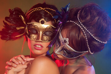 Couple of sensual women with colorful makeup and carnival masks