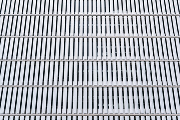 Ultra-modern facade of a building in a sequential pattern of rectangular white plates made of metal that preserve privacy inside the building and allow it to receive sunlight inside