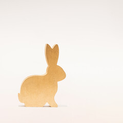 Minimal composition of golden rabbit on a white background. Lunar, Chinese New Year concept for 2023. Year of the Rabbit. Creative greeting card in a minimalist style.