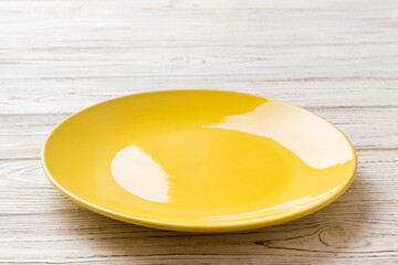 Perspective view of empty yellow plate on cement background. Empty space for your design