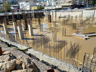 Construction of a monolithic-frame building, unfinished foundation with reinforced concrete columns...