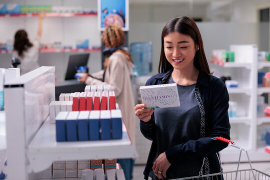 Cheerful client analyzing medications in drugstore looking at pharmaceutical pills package, reading prescription. Customer shopping for prescripted medications to cure disease. Pharmaceutics shop