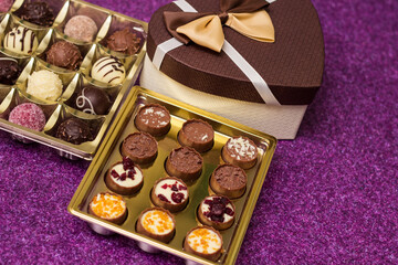 Box with delicious chocolate candies and heart shape gift