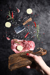 Art photo levitation of a meat steak with ingredients for frying oil spices