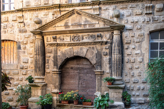 Close-up of an old wooden door on a carved stone wall in the town of Florac in France