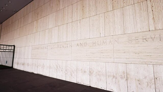 ‘Department of Health and Human Services’ text engraved on the side of the Hubert H. Humphrey Building, the agency headquarters of HHS located in downtown Washington, DC. The camera pans to the right.