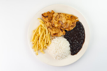 Delicious executive dish of chicken fillet, rice, beans, french fries and green salad with lettuce, tomato and onion accompanied by farofa and vinaigrette. Typical Brazilian food. Selective focus