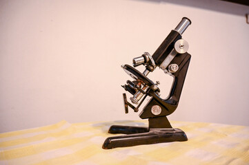 An old microscope. Vintage microscope on the table.