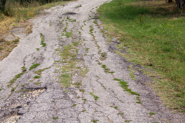 Image of a rough and completely broken and abandoned country road
