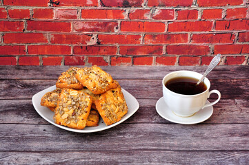 A plate with several shortbread cookies and a cup of hot coffee on a wooden table.