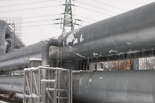 pipeline and power line in the city in winter against the gray sky