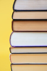 Collection of hardcover books on yellow background