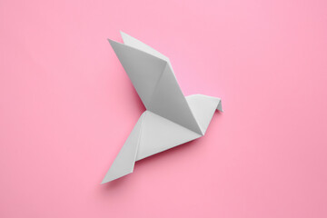 Fototapeta premium Beautiful origami bird on pink background, flat lay
