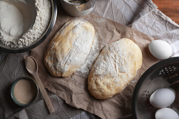 Raw dough, eggs and flour on wooden table, flat lay. Cooking ciabatta