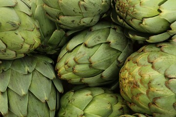 Obraz premium Many fresh raw artichokes as background, top view