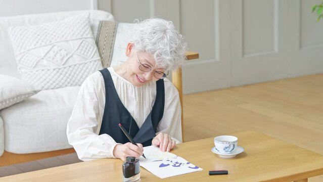 インクで文字を書くシニア女性