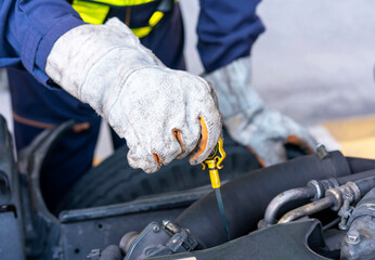Closeup of mechanic's hands checking oil engine.