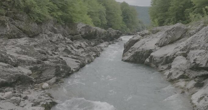 Aerial view of Mountain river and road. Flying over a mountain gorge. Slow motion 120 fps, ProRes 422, 10 bit ungraded DJI D-LOG video