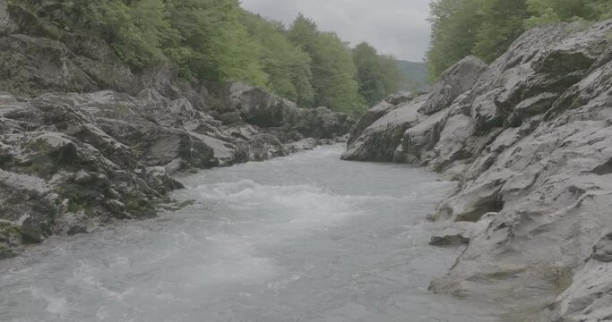 Aerial view of Mountain river and road. Flying over a mountain gorge. Slow motion 120 fps, ProRes 422, 10 bit ungraded DJI D-LOG video