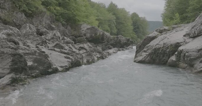 Aerial view of Mountain river and road. Flying over a mountain gorge. Slow motion 120 fps, ProRes 422, 10 bit ungraded DJI D-LOG video