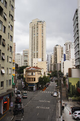 Fototapeta na wymiar Street in the center of São Paulo. Urban photography. Buildings and cars, grey sky.