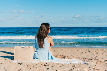 Fototapeta na wymiar Young beautiful woman on the beach look at the sea