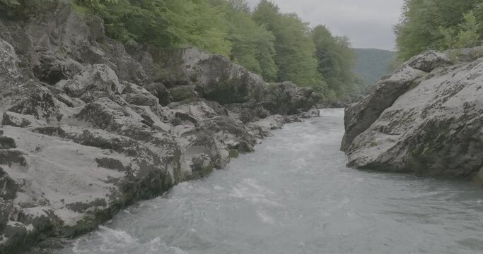 Aerial view of Mountain river and road. Flying over a mountain gorge. Slow motion 120 fps, ProRes 422, 10 bit ungraded DJI D-LOG video