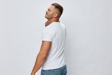 Man back pain neck and joints, bone and spine problems, inflammation and trauma, in white T-shirt on white isolated background, copy space