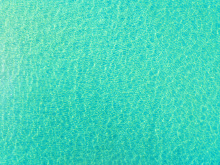 Top view of blue sea surface, Shot in the open sea from above,Amazing nature background of Turquoise Water surface waves reflecting the Sunlight.