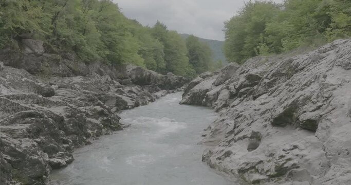 Aerial view of Mountain river and road. Flying over a mountain gorge. Slow motion 120 fps, ProRes 422, 10 bit ungraded DJI D-LOG video