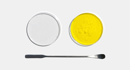 Potassium Chromate Powder in Petri dish with plastic lid placed next to the stainless spatula on laboratory table.