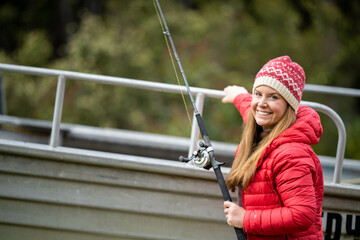 girl in a dinghy fishing with a fishing rod while camping in america. woman fishing