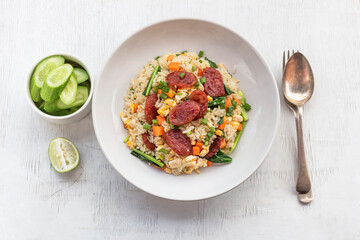 Chinese sausage fried rice on white wood table.