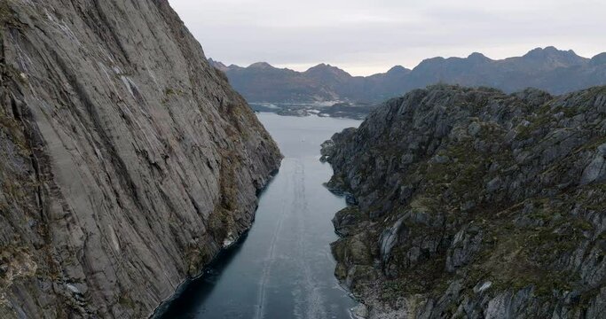 Aerial drone ascending view between rocky walls of Trollfjord or Trollfjorden fjord in Norway