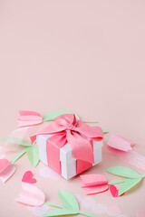 Holiday pink background with gift, luxury pink satin bow, ribbon, paper cut flowers. Valentine's Day, Happy Women's Day, Mother's Day, Birthday, Wedding. Space for text, stylish flyer, greeting card - 553899128