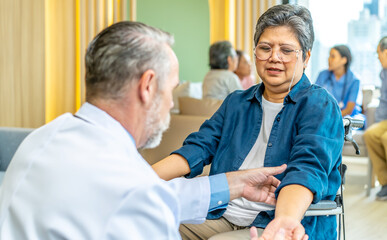 Happy patient and doctor, rehabilitation after injuries, male physiotherapist raising hands of active senior woman in hospital, Musculoskeletal Pain Therapy and Rehabilitation Concept for Senior